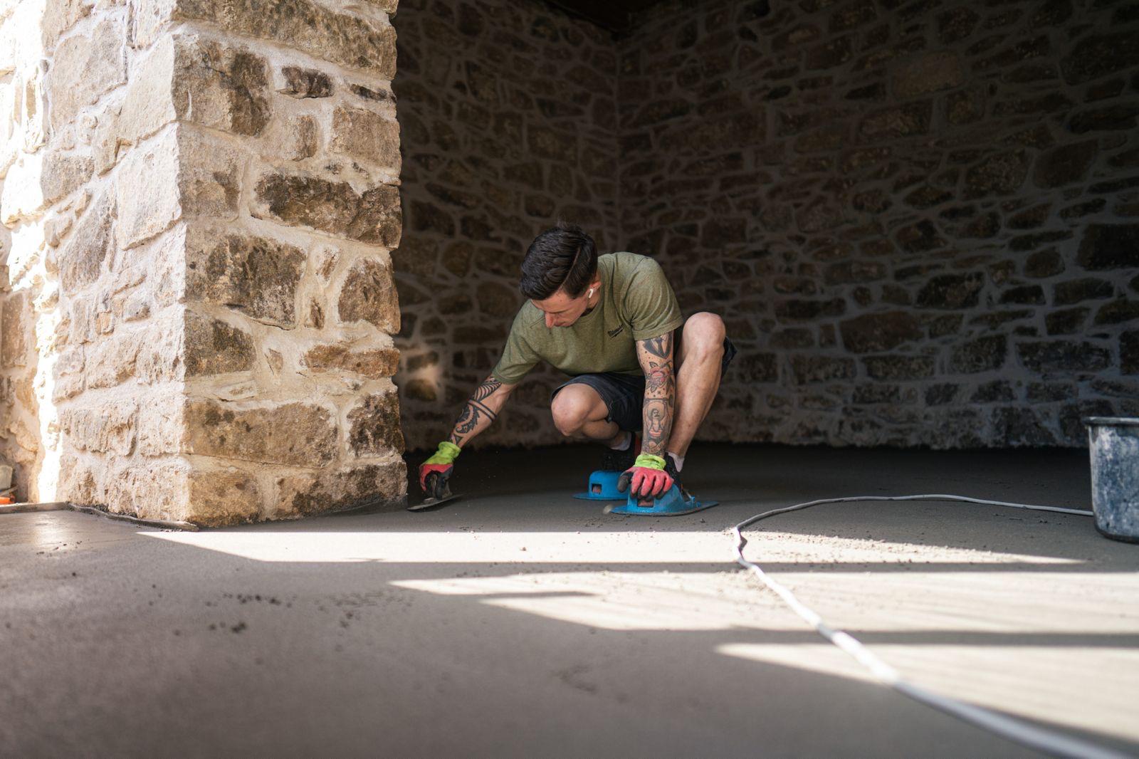 Ruční dohlazení betonové podlahy u kamenné zdi